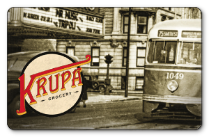 krupa logo over rustic photo of bus passing movie theater